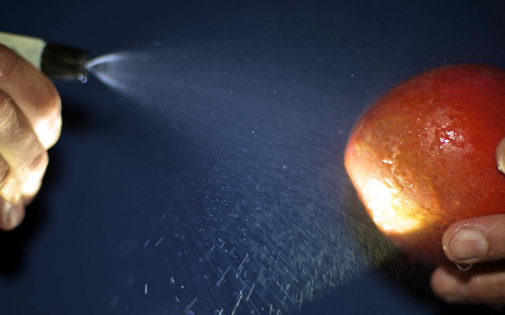 DNA spray An apple is sprayed with DNATrax, a spray infused with DNA that can help determine if produce is organic or genetically modified.