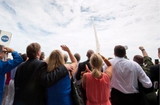 Guests look on from the terrace of Operations Support Building II as space shuttle Atlantis launches from launch pad 39A on the STS-135 mission on July 8, 2011 at the NASA Kennedy Space Center in Cape Canaveral, Florida.