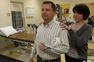 Orthopedist Popi Gianakouras helps 45-year-old Bob Rothaker with physical therapy to treat his sore shoulder.