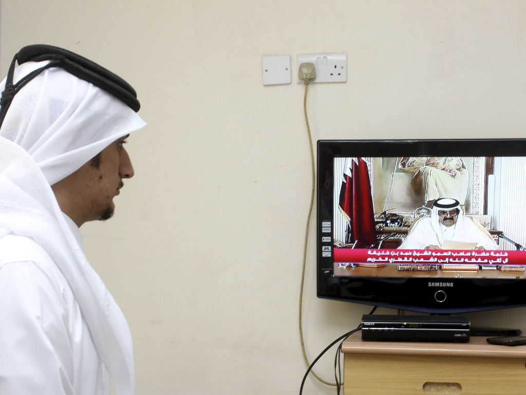 A man watches a televised address by Qatar's Emir Sheik Hamad bin Khalifa Al Thani, in Doha, Qatar, on Tuesday. Qatar's ruler transferred power to his 33-year-old son, making him the youngest leader in the region.
