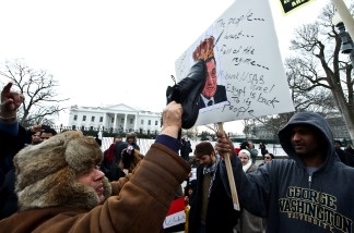 A man hits a picture of Egyptian President Hosni Mubarak with his shoe as people demonstrate in support of the Egyptian people's protests against Mubarak's regime in front of the White House on Jan. 29, 2011.