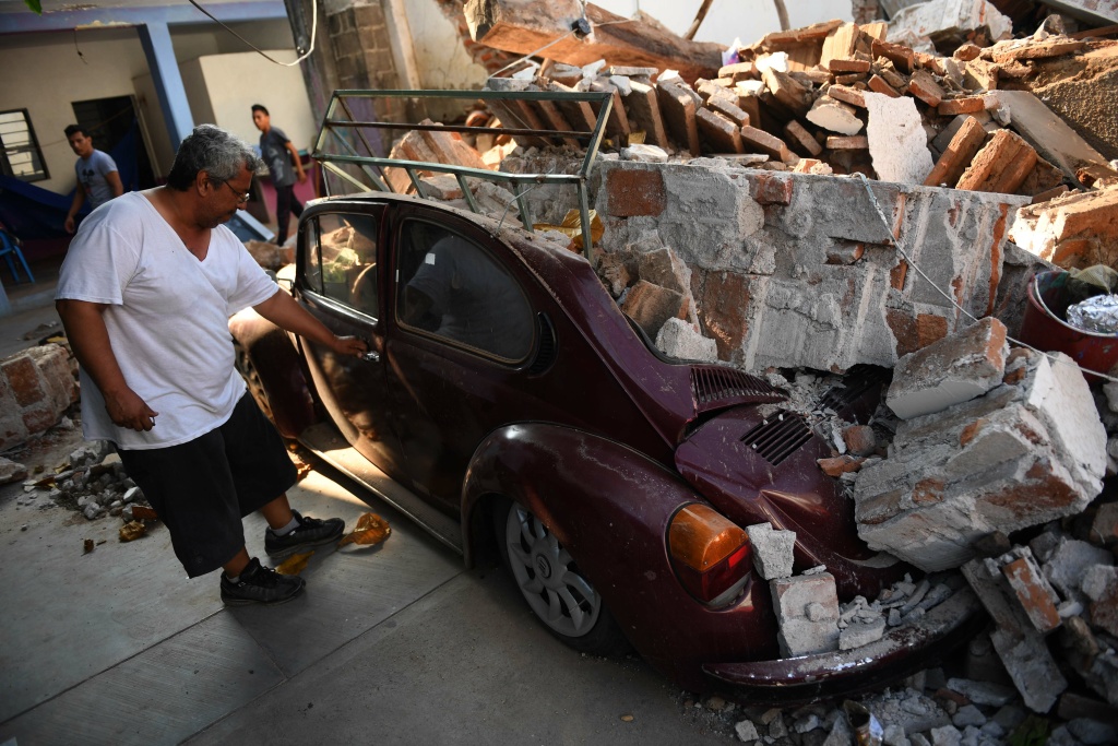 MEXICO-QUAKE A man inspects his car, which was crushed by debris from his house during the powerful earthquake that struck Mexico's Pacific coast late on September 7, 2017 in Juchitan de Zaragoza, Mexico.