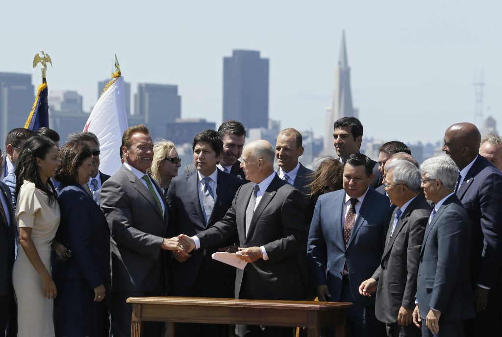 California Climate Change California Gov. Jerry Brown, right, shakes hands with former Gov. Arnold Schwarzenegger, left, after signing a climate bill on Treasure Island, Tuesday, July 25, 2017, in San Francisco. Gov. Brown signed legislation keeping alive California's signature initiative to fight global warming, which puts a cap and a price on climate-changing emissions. The Democratic governor was joined by his celebrity predecessor, Arnold Schwarzenegger, who signed the 2006 bill that led to the creation of the nation's only cap and trade system to reduce greenhouse gases in all industries.