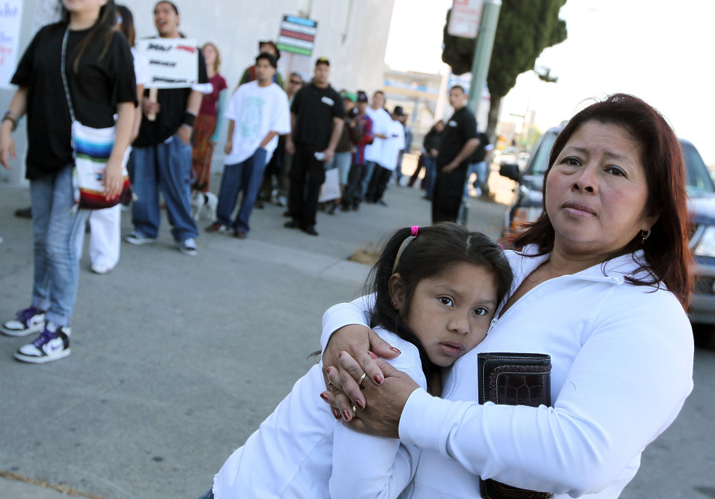 A woman embraces her child as they watch the group