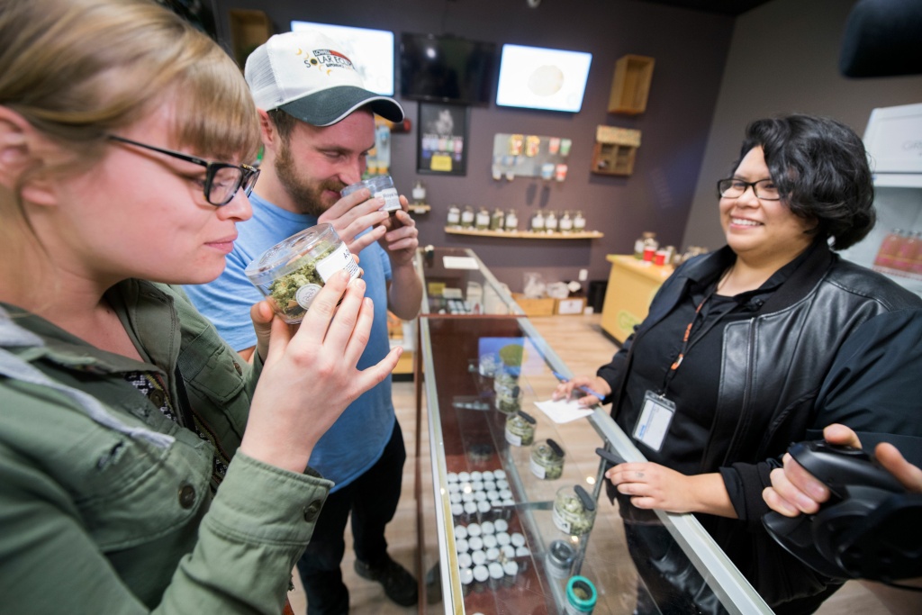 DOUNIAMAG-LIFESTYLE-US-HEALTH-BUSINESS Laura Torgerson and Ryan Sheehan, visiting from Arizona, smell cannabis buds at the Green Pearl Organics dispensary on the first day of legal recreational marijuana sales in California, January 1, 2018 in Desert Hot Springs, California.