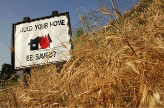 Dry grasses surround a sign in Kagel Canyon that encourages home owners to clear vegetation that could fuel a wildfire from around their properties near Los Angeles, California.