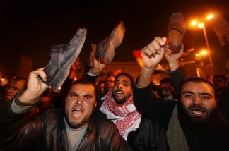 Anti-government protestors waves their shoes, in a gesture of anger, after President Hosni Mubarak announces that he will not seek re-election on Feb. 1, 2011 in Cairo, Egypt.