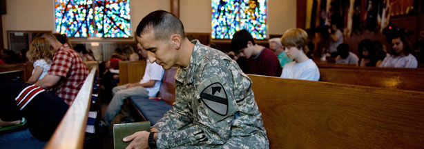 US Army Chaplain 1st Lt. Joshua Remy prays alongside fellow parishoners as he attends non-denominational church services at Fort Hood's 1st Air Cavalry Divisional Memorial Chapel, November 8, 2009 in Killeen, Texas.