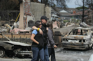 A couple walks by homes that were destroyed by fire following a deadly gas main explosion on September 13, 2010 in San Bruno, California.