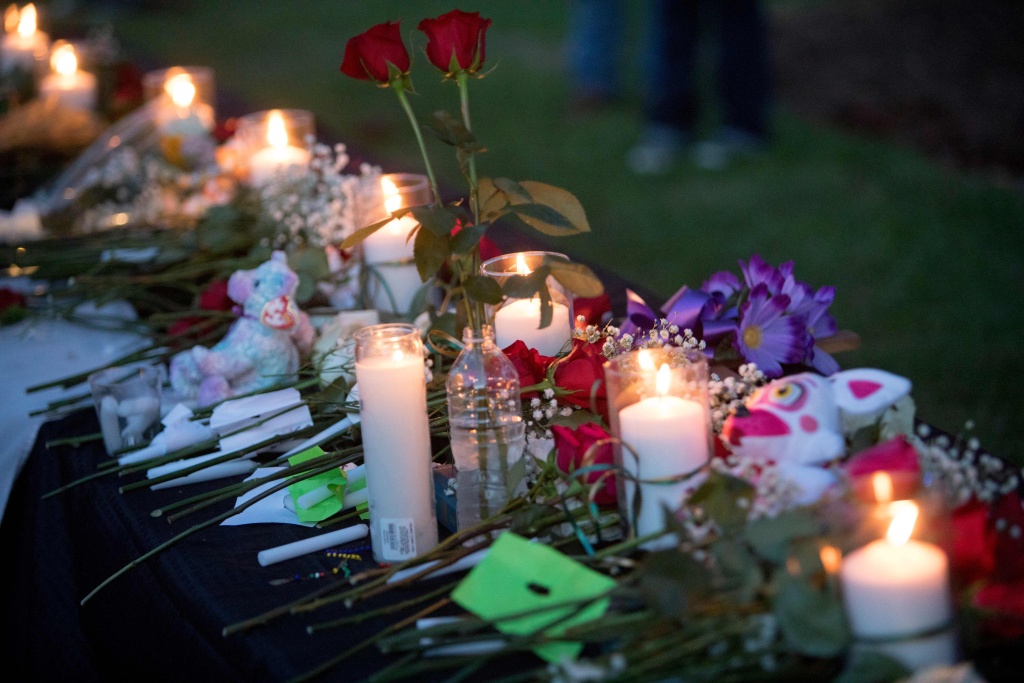 US-SHOOTING-VIGIL Candles, flowers and stuffed animals line a table during a vigil in Santa Fe, Texas for the victims of the mass shooting on May 18, 2018. Ten people, mostly students, were killed when a teenage classmate armed with a shotgun and a revolver opened fire in a Texas high school May 18, 2018, the latest deadly school shooting to hit the United States.