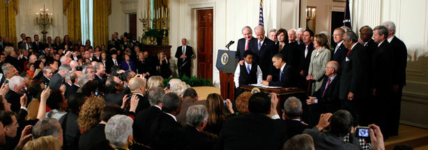 President Barack Obama signs the Affordable Health Care for America Act during a ceremony with fellow Democrats in the East Room of the White House March 23, 2010.