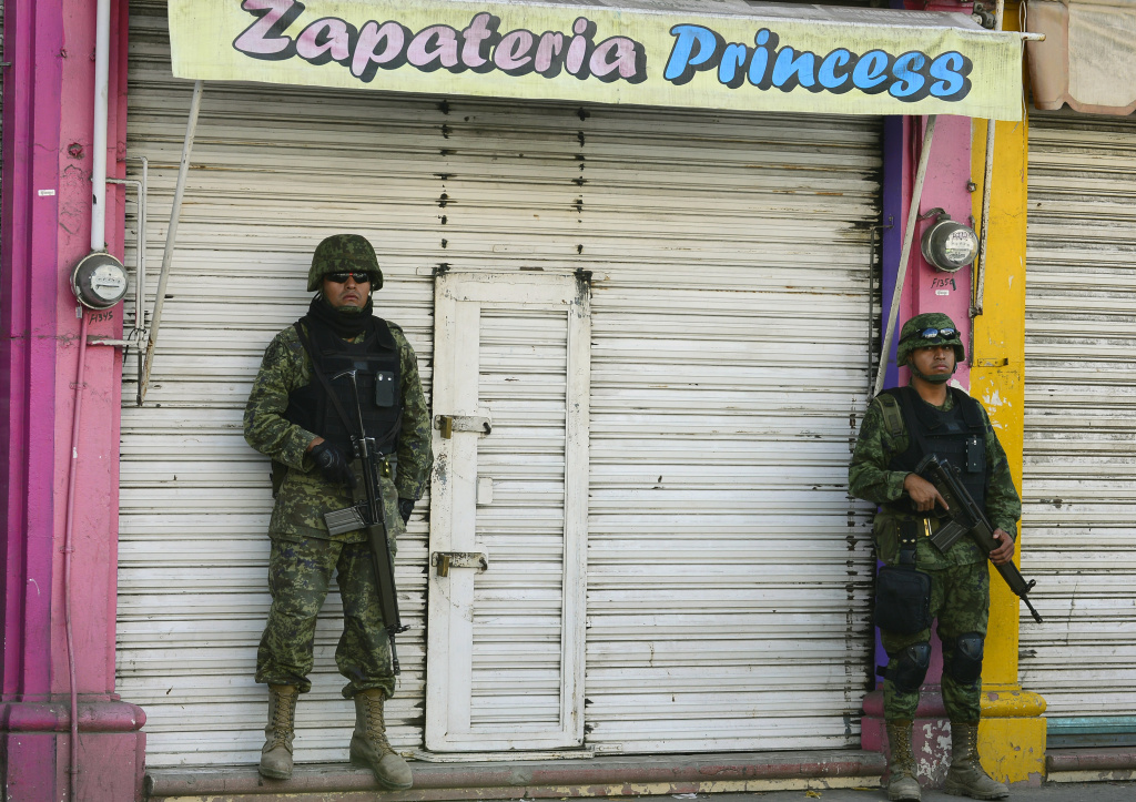 MEXICO-VIOLENCE-MICHOACAN Mexican soldiers patrol the streets of Apatzingan, in Michoacan State, Mexico, on January 16, 2014. The turmoil in Michoacan has become the biggest security challenge for President Enrique Pena Nieto's 13-month-old administration, undermining his pledge to reduce drug violence.