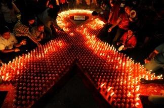 Mercer 12420 Indonesian volunteers light candles during a ceremony to mark World AIDS Day in Jakarta on December 1, 2009. There are estimated to be some 33.4 million people worldwide living with HIV/AIDS, with 2.7 million new cases each year.