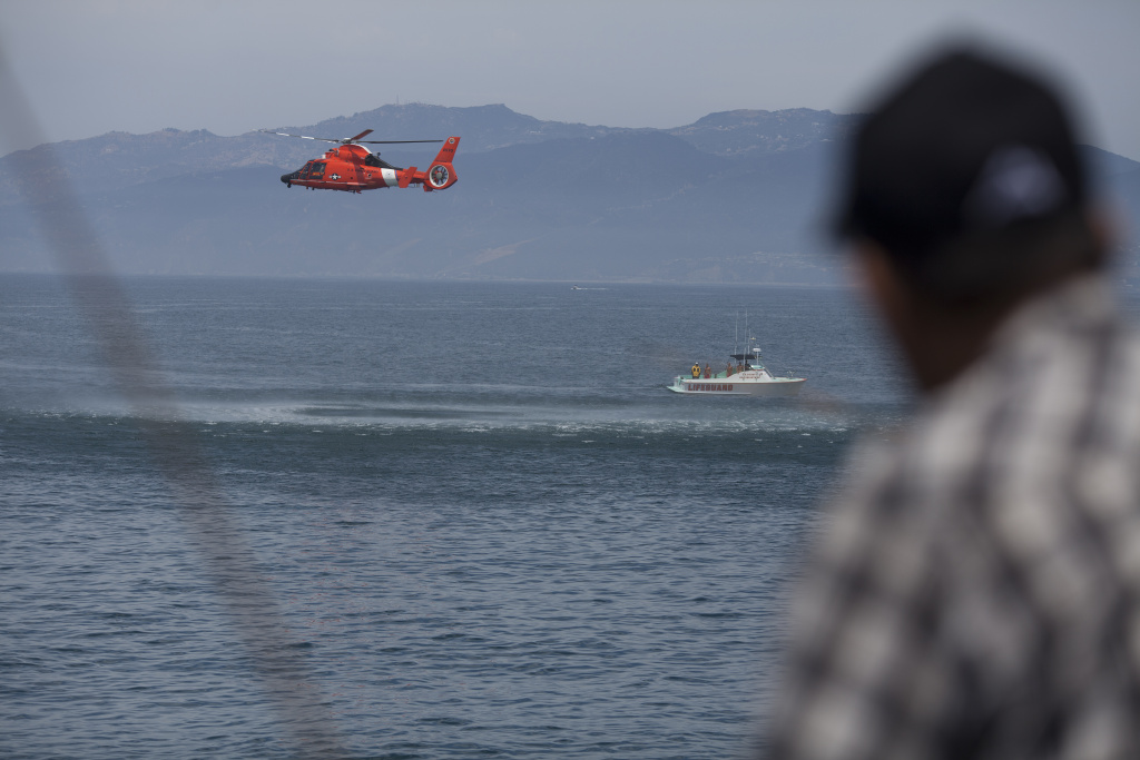 In this file photo, the U.S. Coast Guard performs rescue drills as fishermen look on from the Venice pier a day after a lightning storm killed one person in the ocean nearby. Boats from the Coast Guard and Baywatch, along with helicopters from Los Angeles and San Diego on Monday were assisting in the search for a disabled 17-foot boat that was headed from Catalina Island to Rancho Palos Verdes.