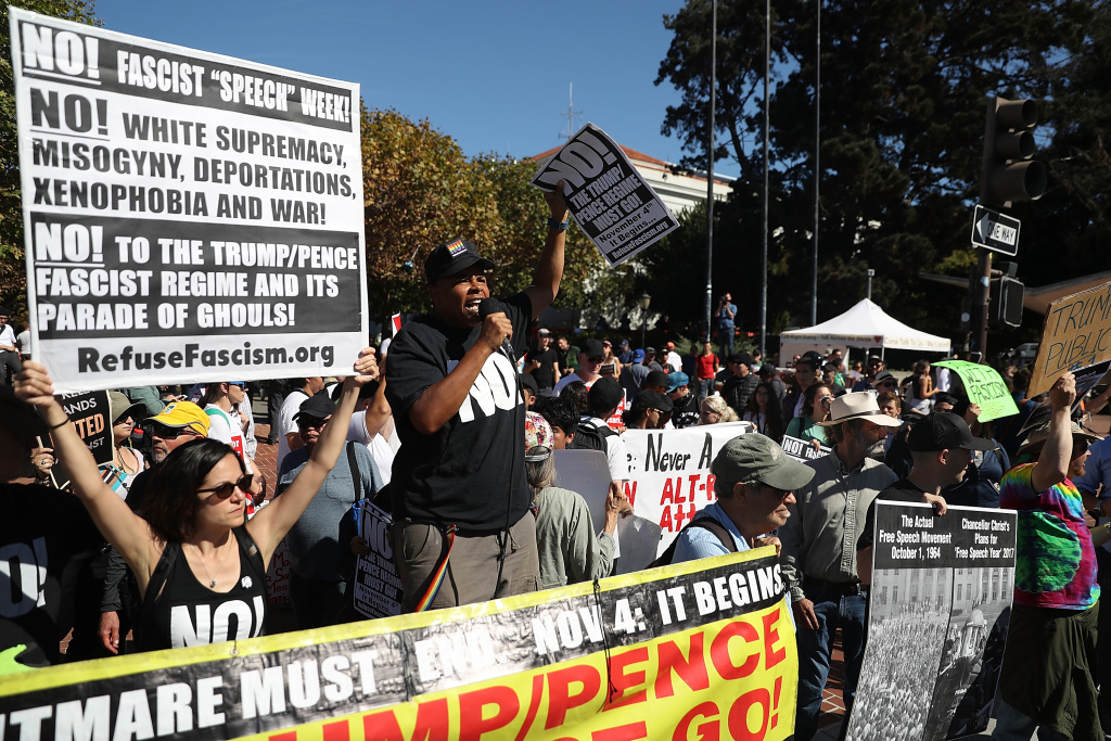 Right Wing Commentator Milo Yiannopoulos Gives Speech At Plaza In Berkeley BERKELEY, CA - SEPTEMBER 24: Protesters hold signs during a free speech rally with right wing commentator Milo Yiannopoulos at U.C. Berkeley on September 24, 2017 in Berkeley, California. Hundreds of protesters came out to support and demonstrate against Milo Yiannopoulos as he held a free speech rally at U.C. Berkeley. (Photo by Justin Sullivan/Getty Images)