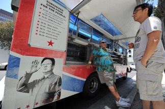 A customer reads the menu on the 'Pyongyang Express' food truck in Los Angeles.