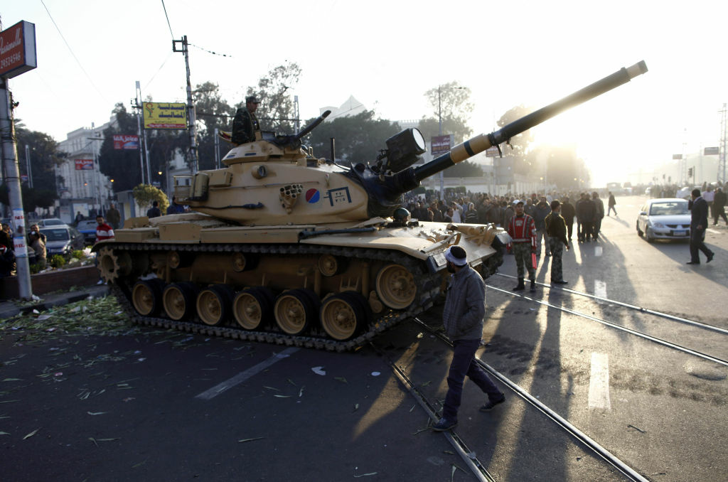 EGYPT-POLITICS-CONSTITUTION-UNREST-ARMY Egyptians walk past army tanks deployed near the presidential palace in Cairo after five demonstrators died overnight in clashes between supporters and opponents of Islamist President Mohamed Morsi on December 6, 2012. Morsi was expected to issue a statement to address the worst violence since his June election, which has pitted Islamists against an opposition that has escalated protests since he assumed extensive powers on November 22.