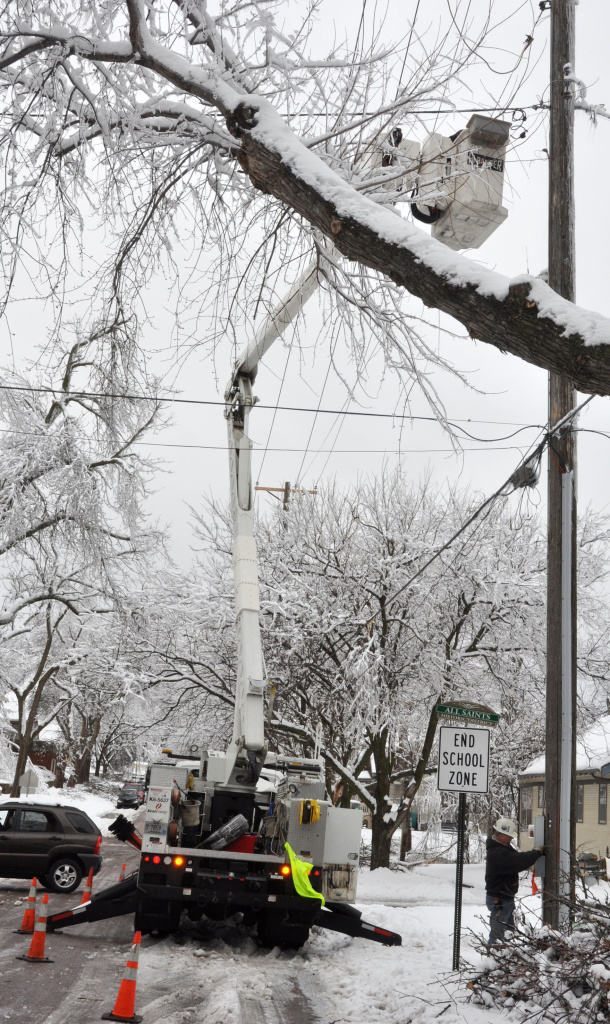 An Xcel Energy crew works to restore a storm-damaged power line on Friday in Sioux Falls, S.D. More than 18,000 homes in the region were without power after a major spring storm brought freezing rain and heavy snow that downed trees and power lines.
