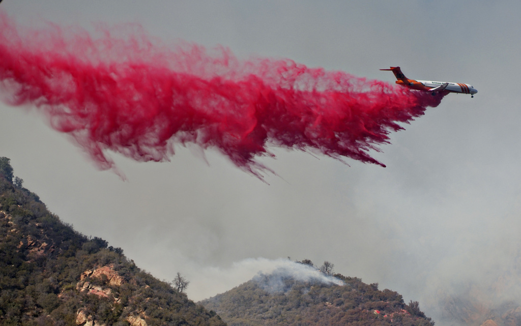 An air tanker drops fire retardant on flames on November 10, 2018 in Malibu, California An air tanker drops fire retardant on flames on November 10, 2018 in Malibu, California