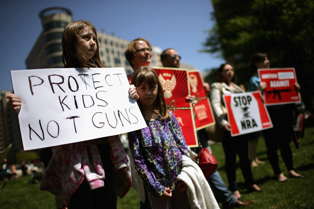 Proponents Of Increased Gun Control Laws Demonstrate In Washington Anti-gun violence demonstrators, including Rachel Ahrens (L), 13, Abby Ahrens, 8, and their mother Betty Ahrens hold signs condeming the National Rifle Association during a protest in McPhearson Square April 25, 2013 in Washington, DC. Angry with the U.S. Senate's failure to pass an expansion of background checks for people wanting to buy guns, the demonstrators attempted to deliver faux bank checks and crime scene photos to a handful of lobbying firms that represent the NRA.