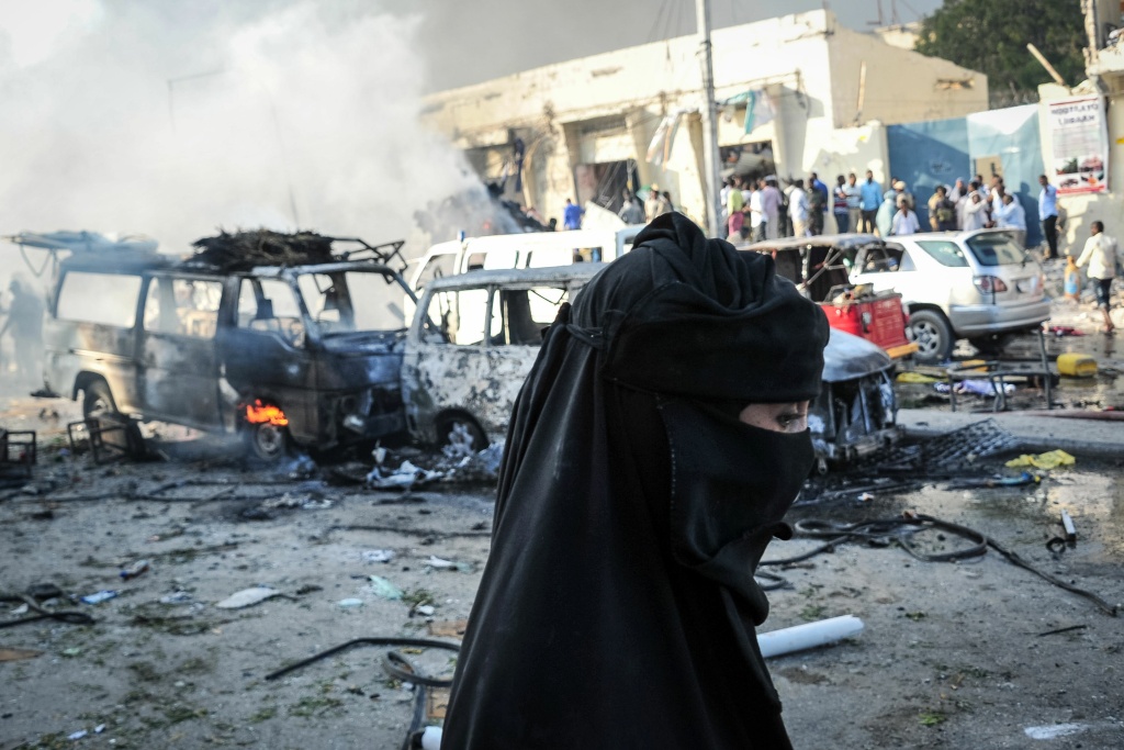 SOMALIA-BOMBINGS-CONFLICT A woman walks by wreckages of vehicles after a truck bomb exploded in the center of Mogadishu on October 15, 2017.