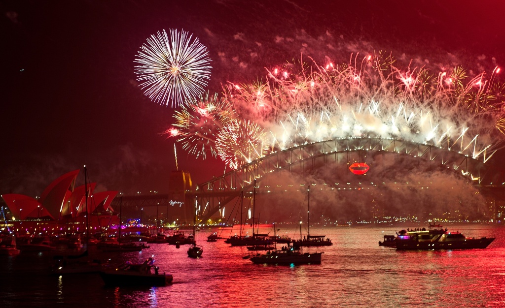 AUSTRALIA-NEW YEAR Spectator boats in Sydney Harbour look on as New Year's Eve fireworks erupt over the Sydney Harbour Bridge on January 1, 2013. Sydney kicked off a wave of dazzling firework displays welcoming in 2013, from Dubai to Moscow and London, with long-isolated Yangon joining the global pyrotechnics for the first time.