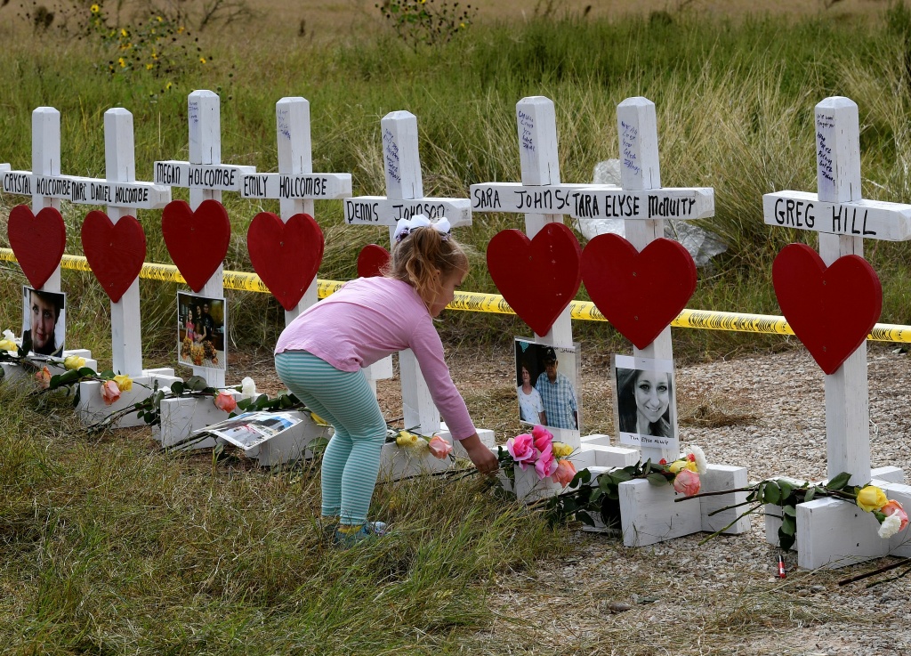 US-CRIME-SHOOTING Shaelyn Gisler, 4, leaves flowers at a memorial where 26 crosses were placed to honor the 26 people killed at the First Baptist Church of Sutherland Springs on November 5, 2017 in Sutherland Springs, Texas.