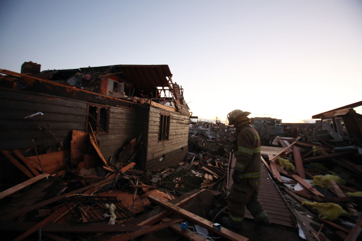 A firefighter searches through debris after a tornado struck on November 17, 2013 in Washington, Illinois. Several tornadoes touched down across the Midwest today with at least three people reported dead in Illinois. 