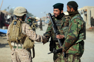 A US Marine of the 2nd Battalion, 1st Marines Regiment (left) shakes hand with Afghanistan National Army soldiers during a patrol in Garmser, Helmand Province, on March 7, 2011.