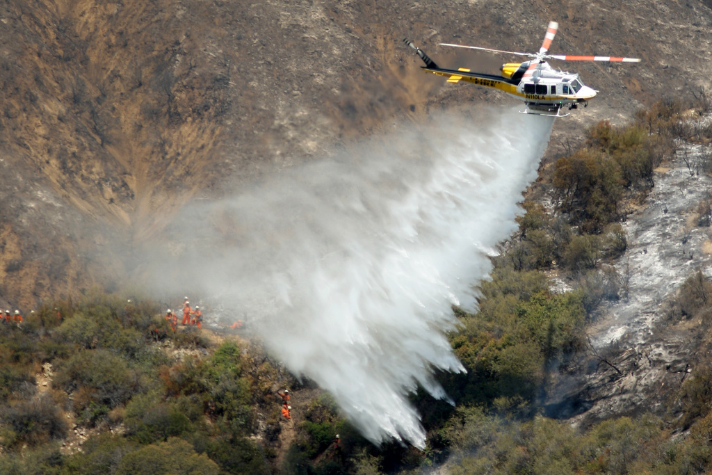 Williams Fire Burns In The Angeles National Forest A Los Angeles County Fire Department helicopter drops water near an inmate hand crew cutting a containment line on a ridge at the Williams fire in the Angeles National Forest on September 4, 2012 north of Glendora, California. The fire began late September 2, putting an early end to Labor Day weekend camping and hiking for vacationers, who were evacuated from the area as it spread to more than 4,000 acres in size. Officials project that it will take at least another week to establish a containment line around the fire which is burning in rugged and difficult to reach backcountry.