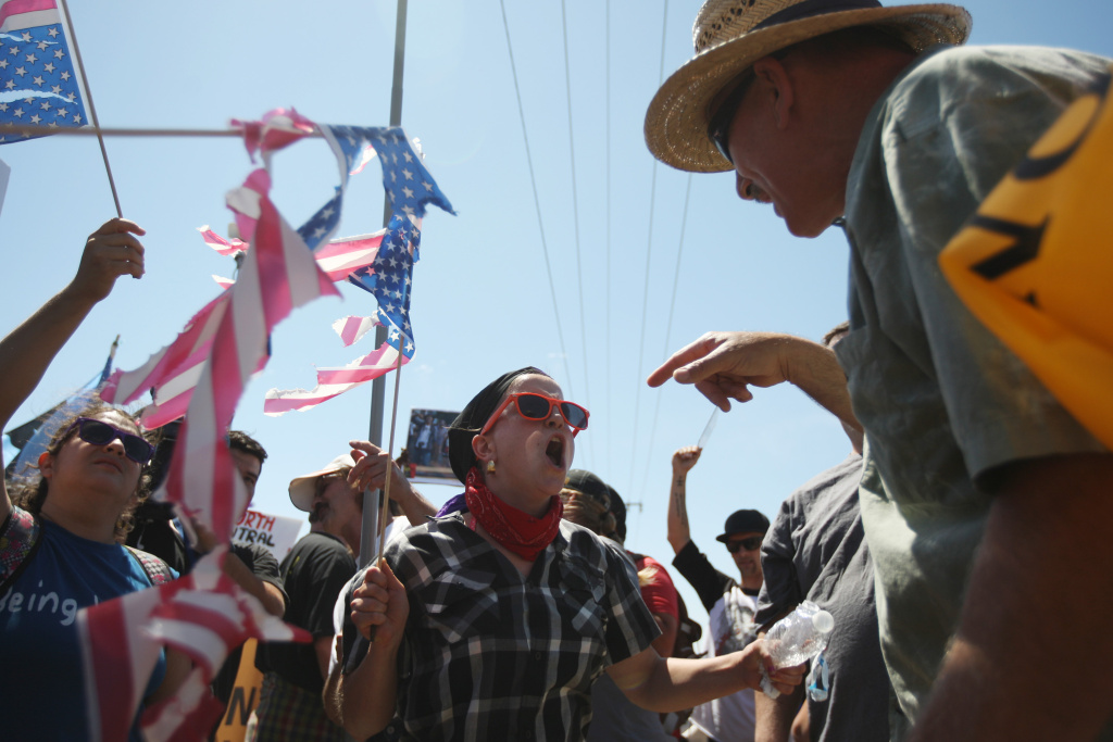 Activists Protest Processing Of Undocumented Immigrants In California Town A protester who opposes arrivals of buses carrying largely women and children undocumented migrants for processing at the Murrieta Border Patrol Station and a counter-demonstrator (L) face off on July 4, 2014 in Murrieta, California. Earlier this week, protesters in the city turned away buses carrying about 140 immigrants that had been apprehended in Texas and flown to California for processing as Texas deals with an influx of immigrants. Federal officials estimate more than 50,000 minors, mostly from Central America, have been caught crossing the border since October 2013.