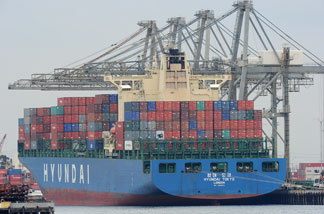 File photo: A container ship being unloaded is visible during the launch voyage of the Aquarium of the Pacific's new 'Urban Ocean' cruise, May 27, 2010 in San Pedro Bay off the coast of Los Angeles and Long Beach, California.
