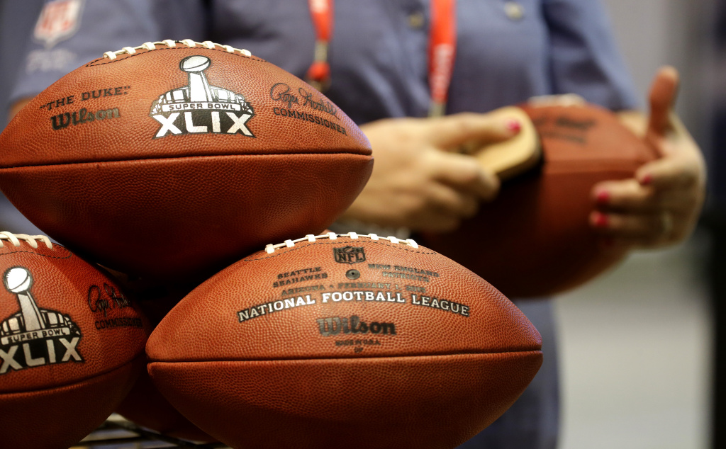 Super Bowl Football An employee of the Wilson Sporting Goods Co. puts the finishing touches on a replica Super Bowl XLIX football at the NFL Experience Saturday, Jan. 24, 2015, in Phoenix. (AP Photo/Charlie Riedel)