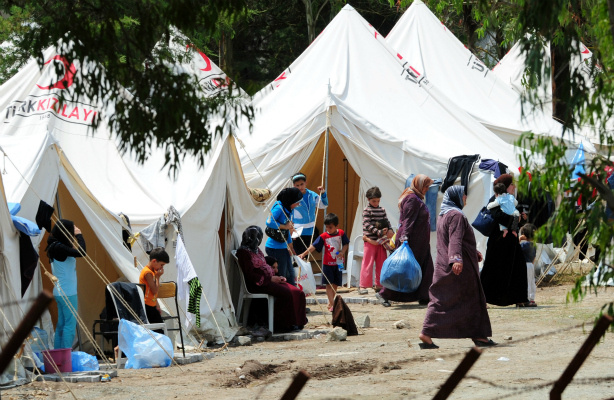 Mercer 18706 Women and children refugees from Syria walk near their tents on June 15, 2011 in the Turkish Red Crescent camp in Hatay's Yayladagi district, Turkey, two kilometers from the Syrian border, on June 15, 2011.