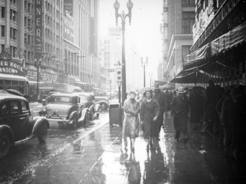 Herman J. Schultheis/Walking in the rain by the Warner Downtown This view looking north on Hill from Seventh Street captures cars driving and people walking in the rain. The movie