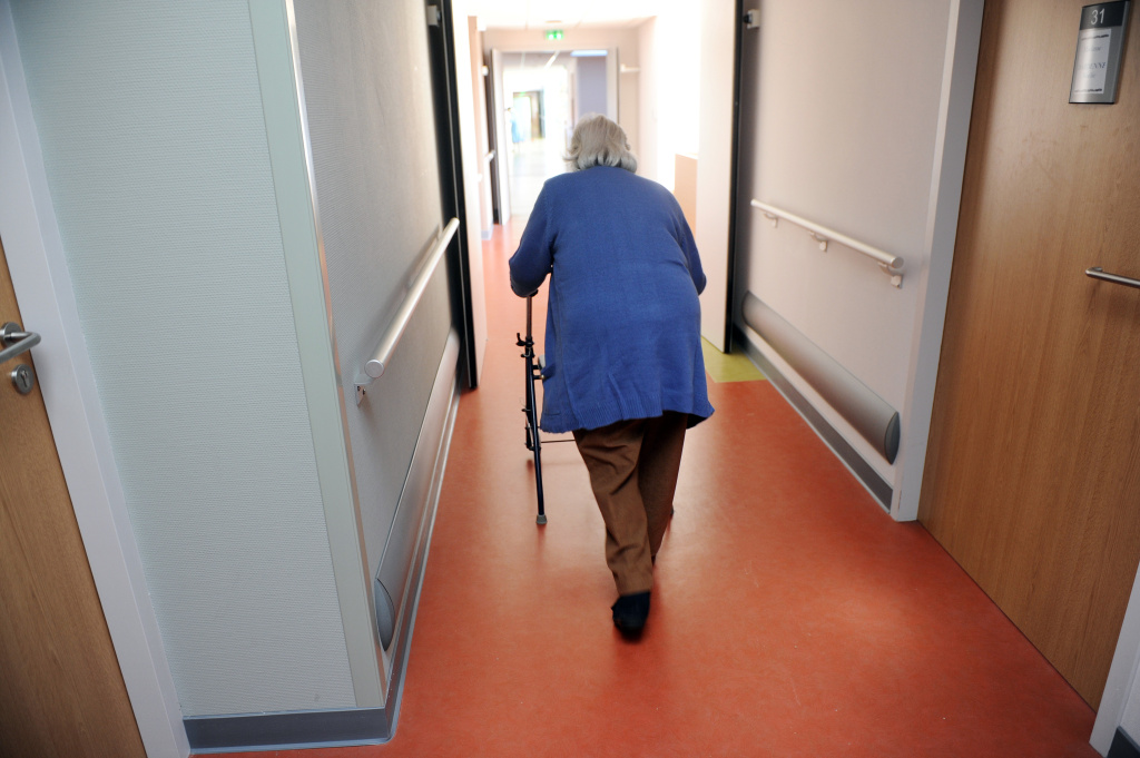 An elderly woman walks with a walker Orange County's rapidly aging population brings challenges, especially in terms of transportation.