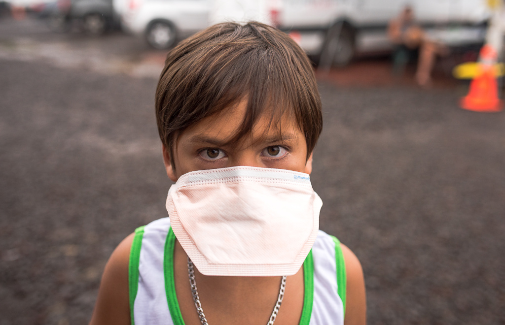 US-HAWAII-VOLCANO A Leilani Estates evacuee tries out a dust mask at The Hub, as Vog levels were particularly high in the area that day in Pahoa, Hawaii on May 17, 2018 due to eruptions from Kilauea volcano.