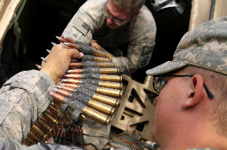 U.S. Army Specialist Craig Cox from Ogden, Utah (R) hands rounds of .50 caliber ammunition to U.S. Army Corporal Zachary Taylor with Task Force Thor Route Clearance Patrol from 23rd Engineering Company, Airborne as they prepare for a day-long route clearance mission July 7, 2010 in Jeluwar, Afghanistan.