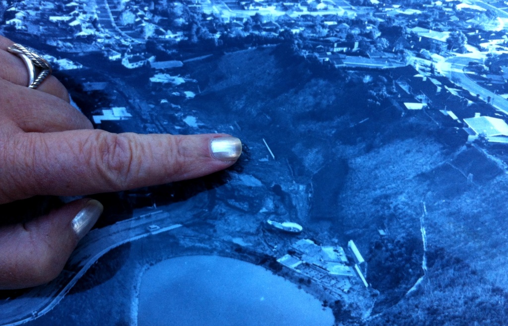 Rhea Coskey points to an aerial photo of the Baldwin Hills Dam collapse devastation. Her thumb is on South Cloverdale Avenue. Her index finger points to her former address: 4601 South Cloverdale Avenue. The home she lived in with her husband and kids was reduced to a single wall, the white line you can see in the blue photo. Rhea Coskey points to an aerial photo of the Baldwin Hills Dam collapse devastation. Her thumb is on South Cloverdale Avenue. Her index finger points to her former address: 4601 South Cloverdale Avenue. The home she lived in with her husband and kids was reduced to a single wall, the white line you can see in the blue photo.