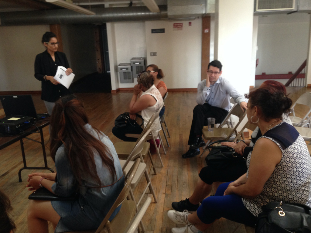 Central American Resource Center staff attorneys Aretha Raza, left, and Eryk Escobar, seated, talk with immigrants at a legal clinic for asylum seekers. The free clinics held at CARECEN teach asylum seekers who can't afford an immigration lawyer to represent themselves in immigration court.