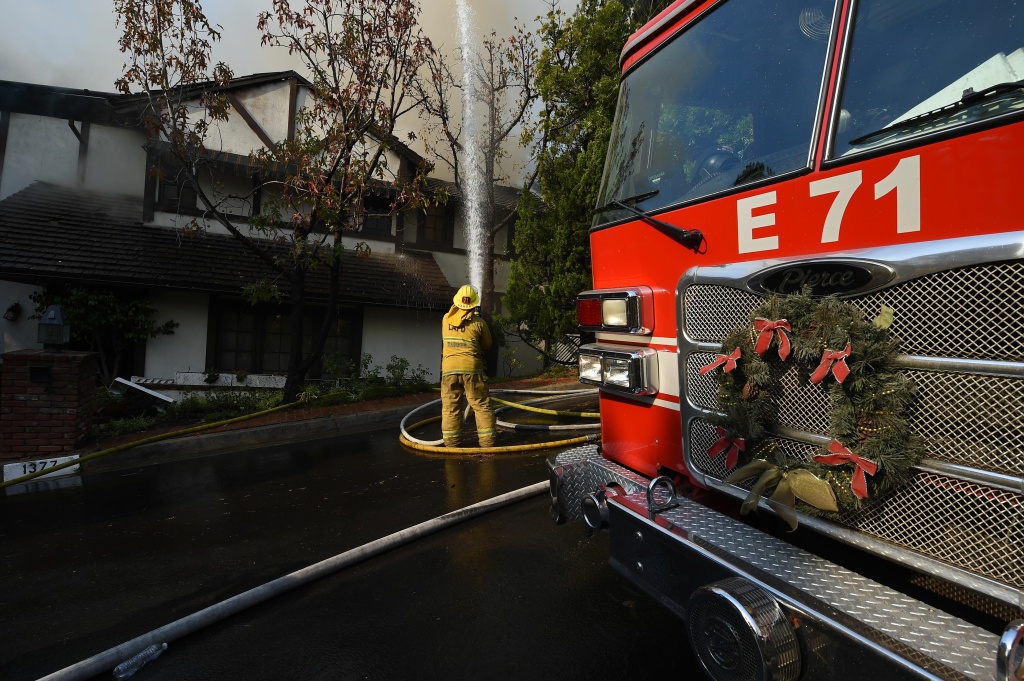 Skirball Fire A firefighter loads belongings into the trunk of a resident's Bentley as she evacuates her Bel Air home, at the the Skirball Fire in west Los Angeles, California, December 6, 2017.