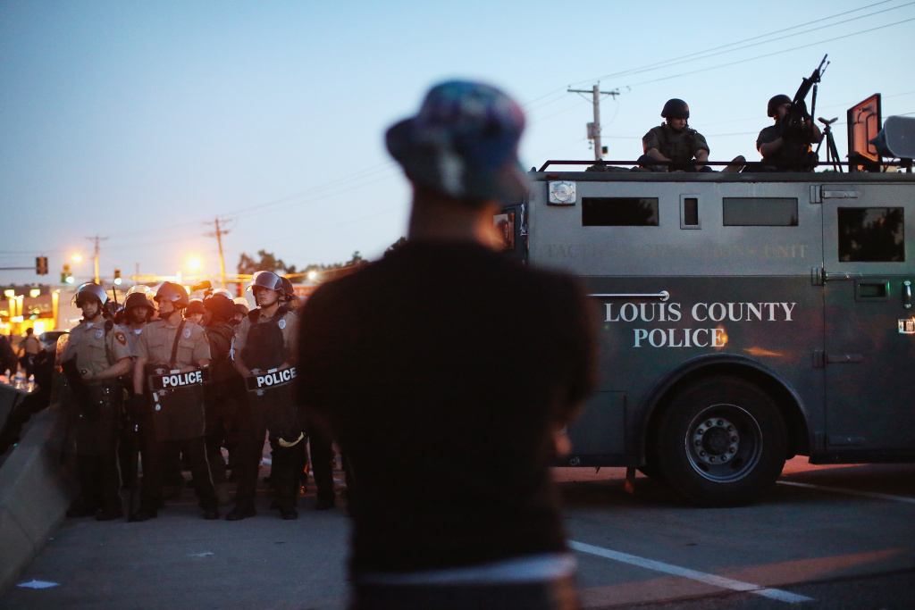 Outrage In Missouri Town After Police Shooting Of 18-Yr-Old Man Police stand watch as demonstrators protest the shooting death of teenager Michael Brown on August 13, 2014 in Ferguson, Missouri. Brown was shot and killed by a Ferguson police officer on Saturday. Ferguson, a St. Louis suburb, is experiencing its fourth day of violent protests since the killing.