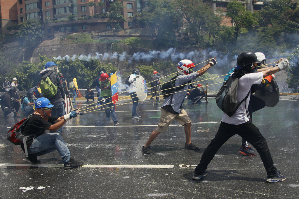 Venezuela protesters Anti-government protesters aim a giant slingshot with a glass bottle containing fecal matter at security forces in Caracas, Venezuela, on May 10.