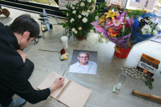 A visitor writes a message for Norman Schureman, a teacher at Art Center College of Design in Pasadena, who was shot on March 21, 2010.
