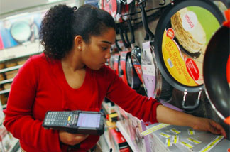Joanely Carrero restocks shelves at a Target store in Miami, Fla. Retailers added 12,000 jobs last month.