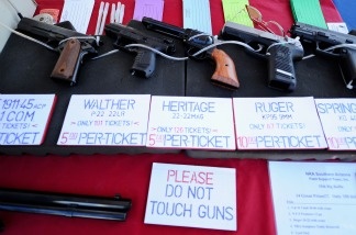 Handguns are displayed for sale at the Crossroads of the West Gun Show at the Pima County Fairgrounds on Jan. 15, 2011 in Tucson. Today marks one week since Jared Lee Loughner killed six and injured several others outside a grocery store in Tuscon.