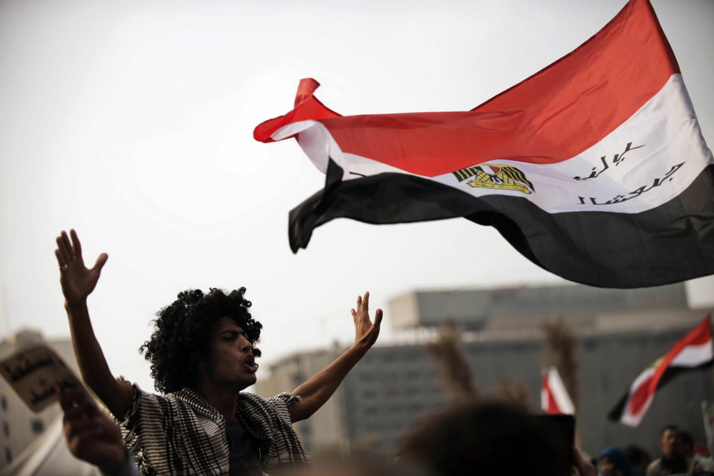 EGYPT-POLITICS-DEMO Egyptian protesters wave their national flag as they shout political slogans against President Mohamed Morsi's decree granting himself broad powers during a demonstration in Cairo's Tahrir Square on November 27, 2012. The planned demonstrations come a day after Morsi met with the country's top judges in a bid to defuse the crisis over the decree, that has sparked deadly clashes and prompted judges and journalists to call for strike.