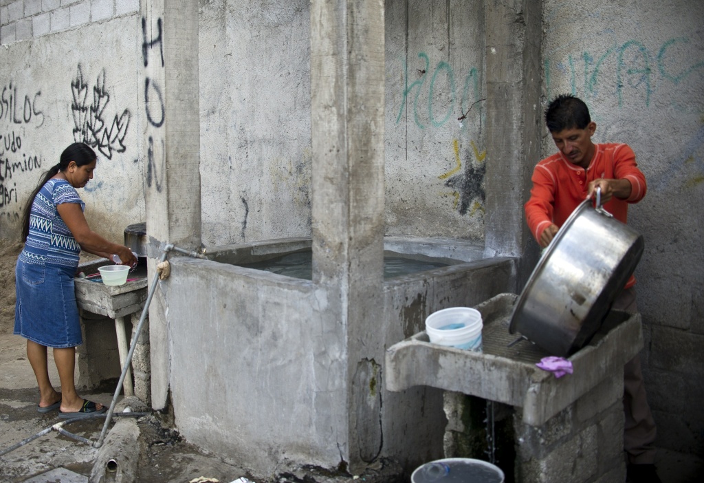 MEXICO-US-MIGRATION Central American migrants clean pots and dishes at the Sagrada Familia shelter as they wait for the so-called La Bestia (The Beast) cargo train, in an attempt to reach the US border, in Apizaco, Tlaxcala state, Mexico on July 22, 2014.