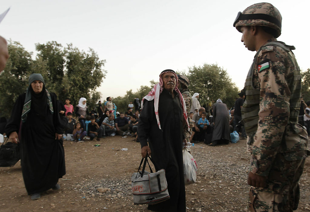 JORDAN-SYRIA-CONFLICT-REFUGEES Jordanian soldiers help newly-arrived Syrian refugees after hundreds fleeing the violence in their home country. Most refugees have fled to neighboring countries, but some have ended up in Southern California.