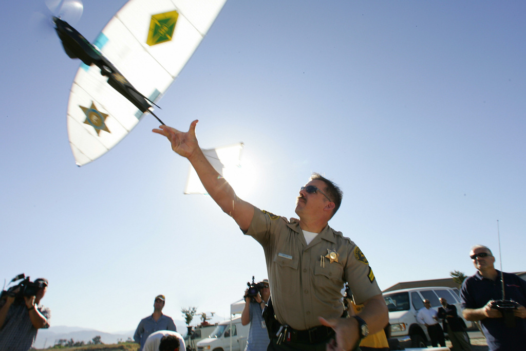 Deputy Troy Sella from the new technolog Deputy Troy Sella from the new technology department of the Los Angeles Sheriff's Department (LASD) launches the SkySeer Unmanned Arial Vehicle (UAV) drone, 16 June 2006 at a demonstration flight in Redlands, California. The LASD plans to purchase SkySeer drones to carry out surveillance and rescue operations. It will be the first time UAVs, long used by the military in war zones, will be used by law enforcement.